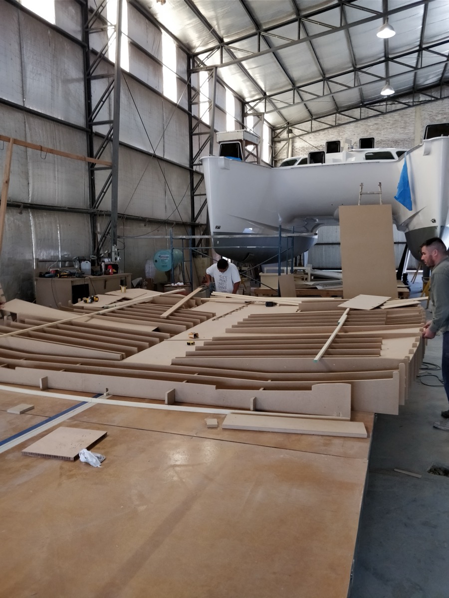 CNC-cut mold sections being assembled for a new catamaran model