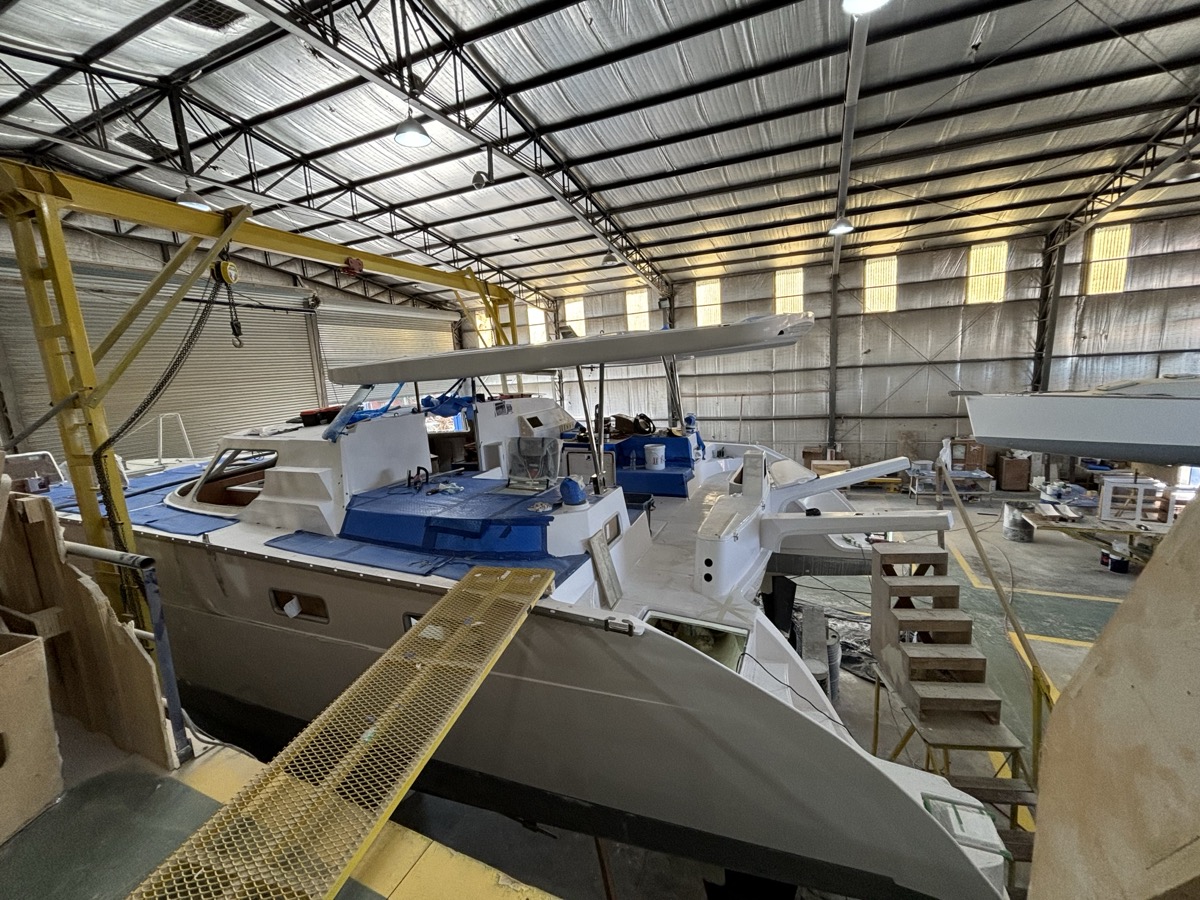 Catamaran in advanced fit-out stage with deck hardware and cockpit